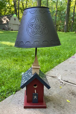 Americana style lamp with a tin shade and birdhouse base