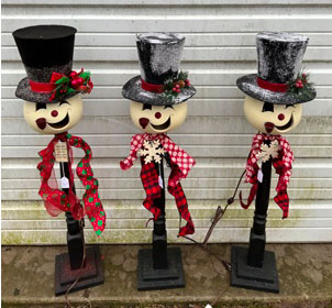 Three snowmen made from gourds with tophats, lights, ribbon and black wooden base.