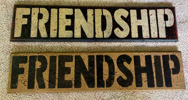 Two wooden stenciled signs that say "Friendship"