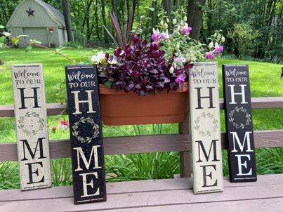 Four wooden signs that  say Welcome to our Home