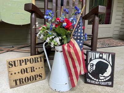 Support our troops sign stenciled in black and a black POW MIA sign stenciled in white