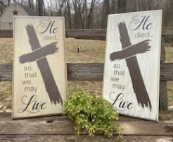 Two wooden stenciled signs that say He died so that we may live