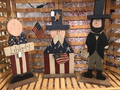 Wooden decorations of Lady Liberty, Uncle Sam, and Abraham Lincoln